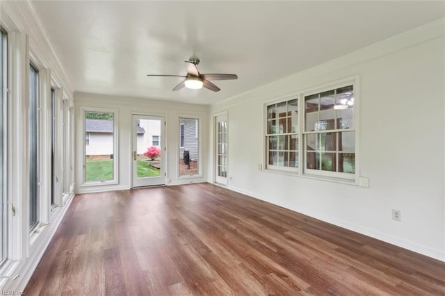 unfurnished sunroom with baseboards and wood finished floors