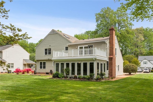 back of property featuring a yard, a chimney, and a balcony