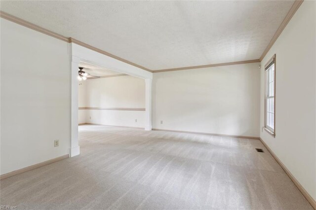 unfurnished room featuring carpet, a textured ceiling, crown molding, and a ceiling fan