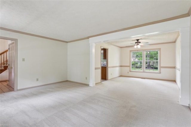 carpeted empty room featuring stairway, ceiling fan, baseboards, and ornamental molding