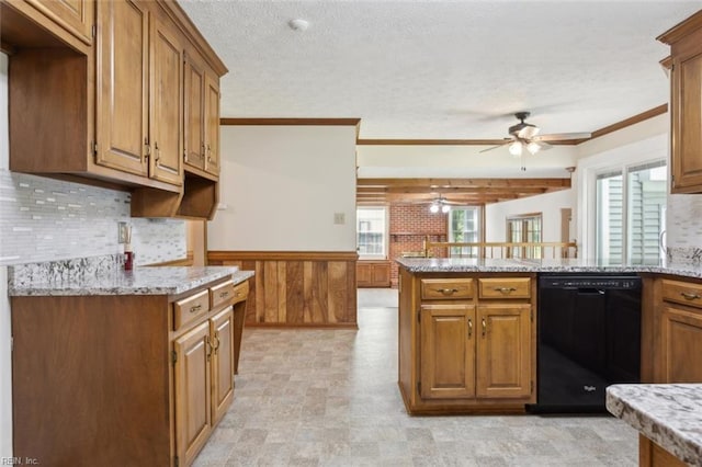 kitchen featuring light stone counters, a ceiling fan, a peninsula, black dishwasher, and brown cabinetry