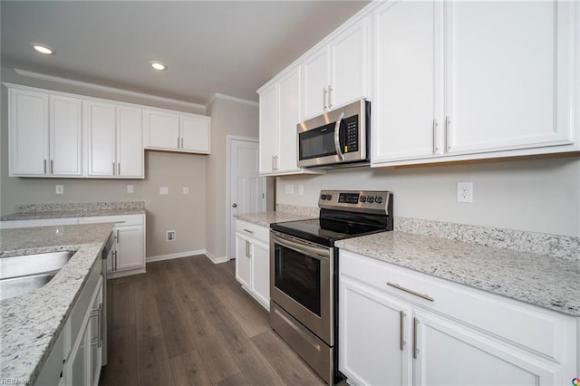 kitchen with light stone counters, stainless steel appliances, baseboards, white cabinetry, and dark wood-type flooring