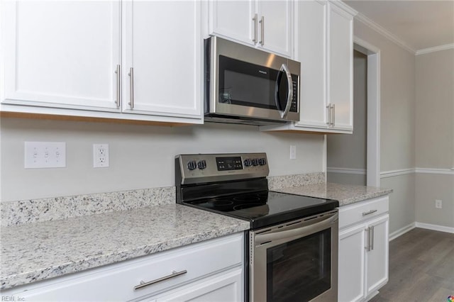 kitchen featuring dark wood-style floors, light stone countertops, crown molding, appliances with stainless steel finishes, and white cabinetry
