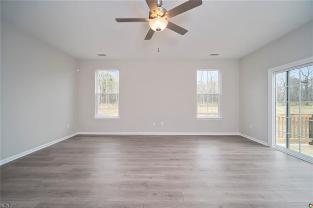 spare room with baseboards, wood finished floors, and ceiling fan