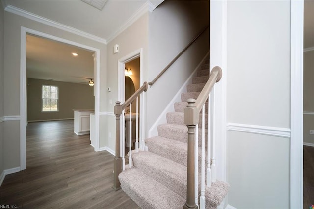 staircase with a ceiling fan, crown molding, wood finished floors, baseboards, and recessed lighting