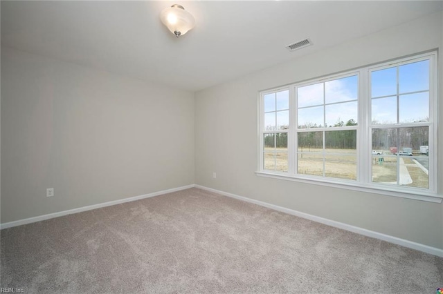 unfurnished room featuring baseboards, visible vents, and carpet floors