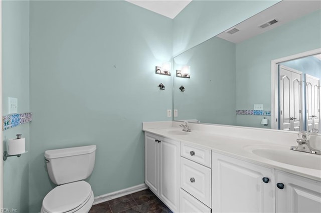 bathroom with visible vents, toilet, baseboards, and a sink