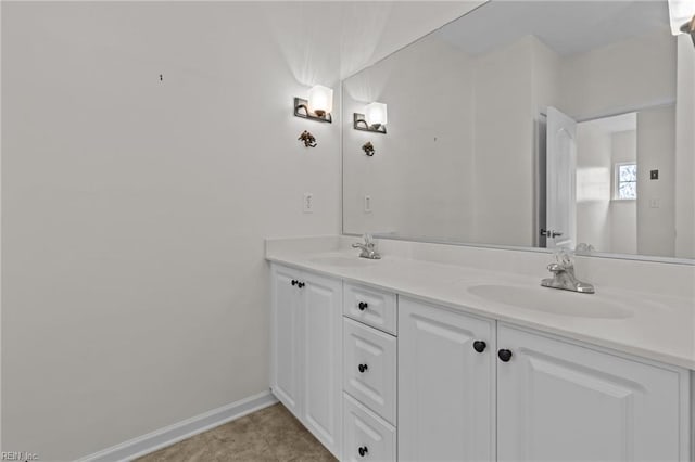full bathroom with baseboards, a sink, and double vanity