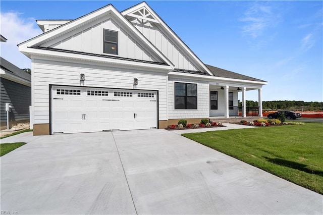 view of front facade with driveway, a porch, board and batten siding, and a front yard