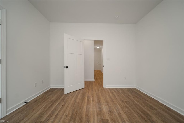 spare room with wood finished floors and baseboards