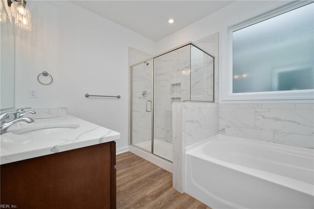full bathroom with a garden tub, wood finished floors, vanity, and a stall shower