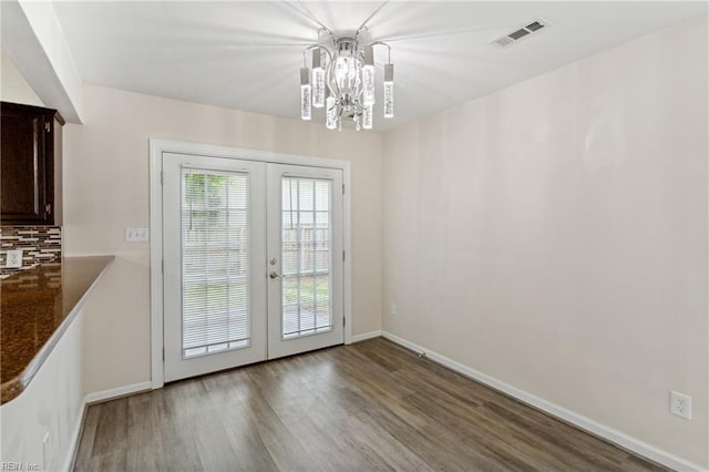 interior space with wood finished floors, visible vents, french doors, baseboards, and a notable chandelier