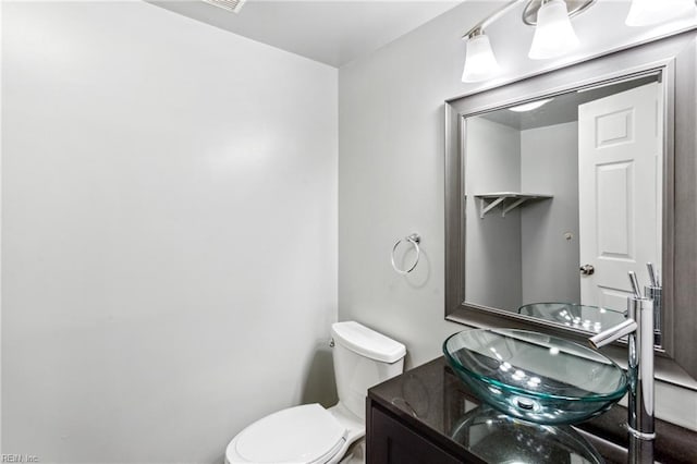 half bathroom featuring vanity and toilet