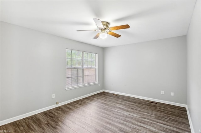 empty room with visible vents, a ceiling fan, baseboards, and dark wood-style flooring