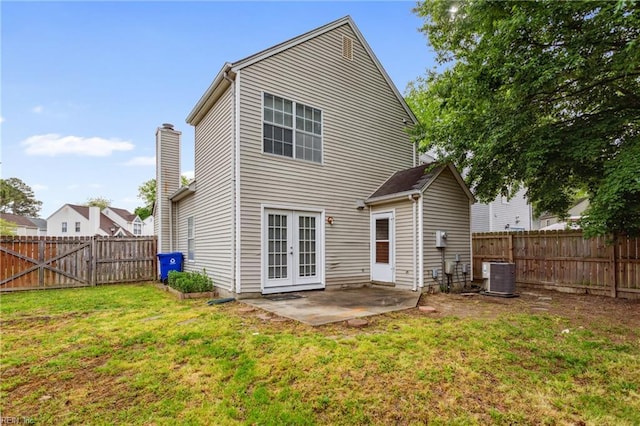 back of property featuring central AC, french doors, a fenced backyard, a yard, and a patio
