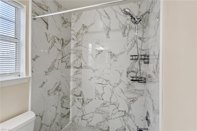 full bathroom featuring toilet and a marble finish shower