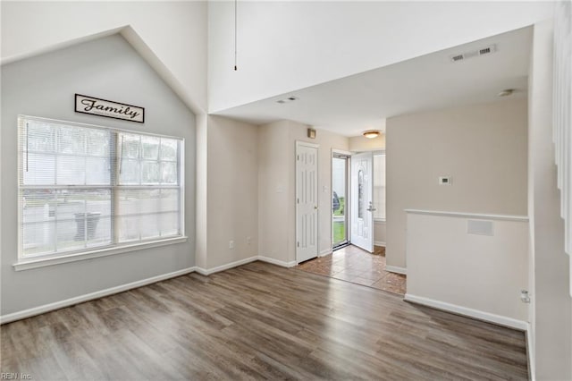 interior space with baseboards, wood finished floors, and visible vents