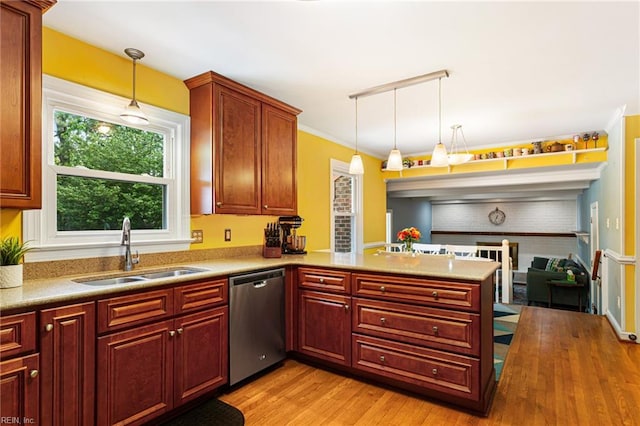 kitchen with stainless steel dishwasher, a sink, light wood-type flooring, pendant lighting, and a peninsula