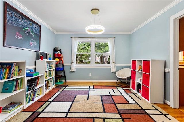 playroom featuring visible vents, baseboards, wood finished floors, and crown molding