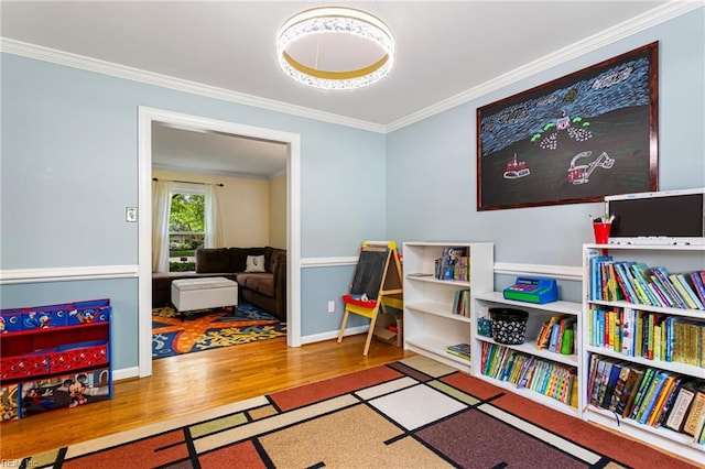 game room featuring baseboards, wood finished floors, and crown molding