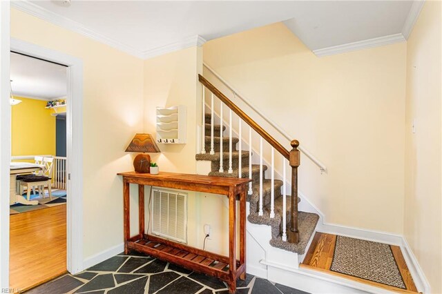 stairs with baseboards, wood finished floors, visible vents, and crown molding