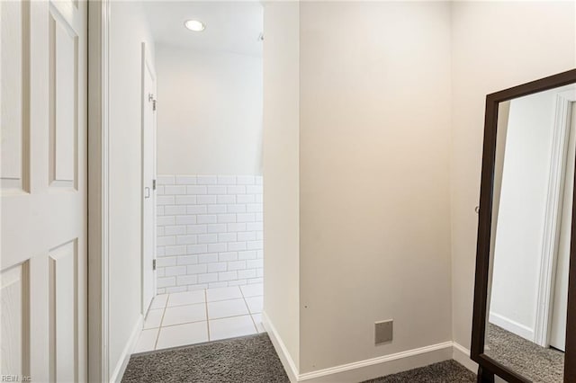 hallway featuring recessed lighting, tile patterned flooring, and baseboards