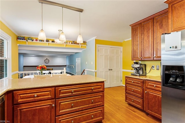kitchen featuring light wood finished floors, ornamental molding, light stone countertops, stainless steel fridge, and hanging light fixtures