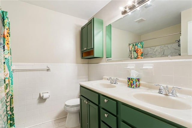 full bath with toilet, a sink, and tile walls