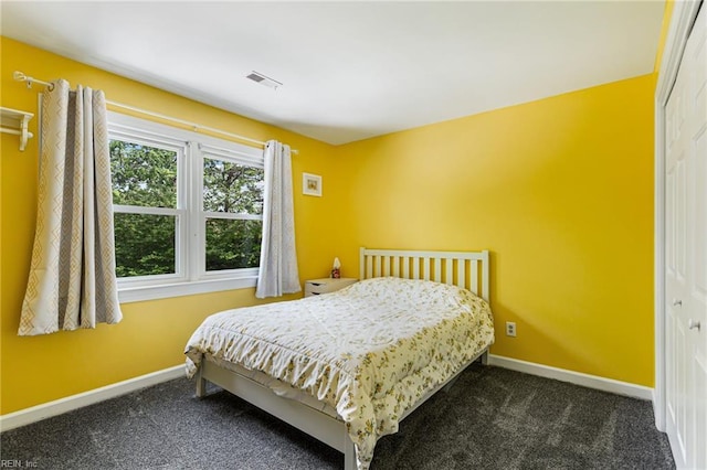 bedroom with baseboards, carpet flooring, visible vents, and a closet