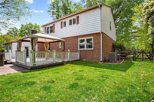 back of house with central AC, a gazebo, fence, a wooden deck, and brick siding