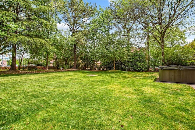 view of yard with fence and a hot tub