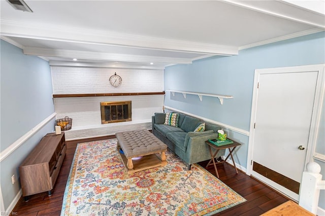 living area with hardwood / wood-style floors, beamed ceiling, baseboards, a brick fireplace, and visible vents