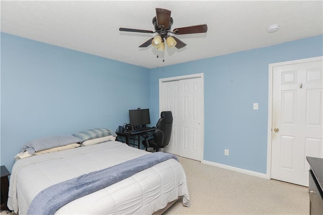 bedroom featuring light carpet, baseboards, a closet, and ceiling fan