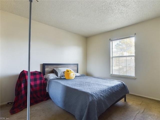 carpeted bedroom with a textured ceiling and baseboards