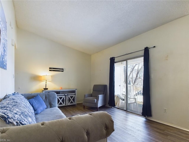 living room featuring a textured ceiling, wood finished floors, lofted ceiling, and baseboards