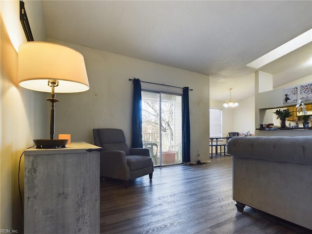 living area with dark wood-style flooring and a notable chandelier