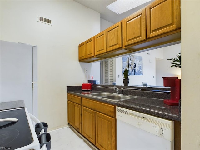 kitchen with a sink, dark countertops, visible vents, white appliances, and brown cabinetry