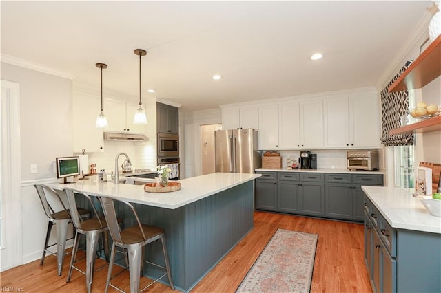 kitchen featuring tasteful backsplash, appliances with stainless steel finishes, gray cabinets, and under cabinet range hood