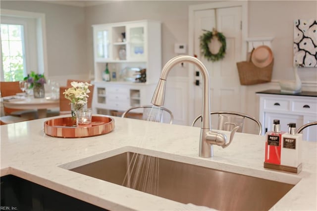 kitchen with light stone counters and a sink