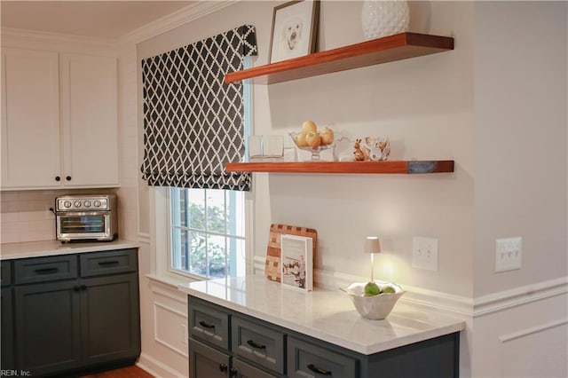 interior space with tasteful backsplash, a toaster, and ornamental molding