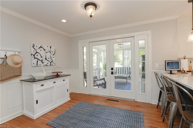 doorway to outside with ornamental molding, french doors, light wood-style floors, and visible vents