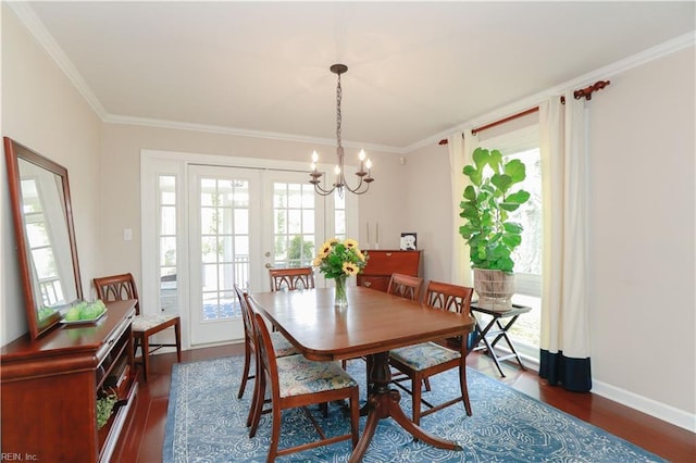 dining area with crown molding, a chandelier, dark wood-style floors, and a healthy amount of sunlight
