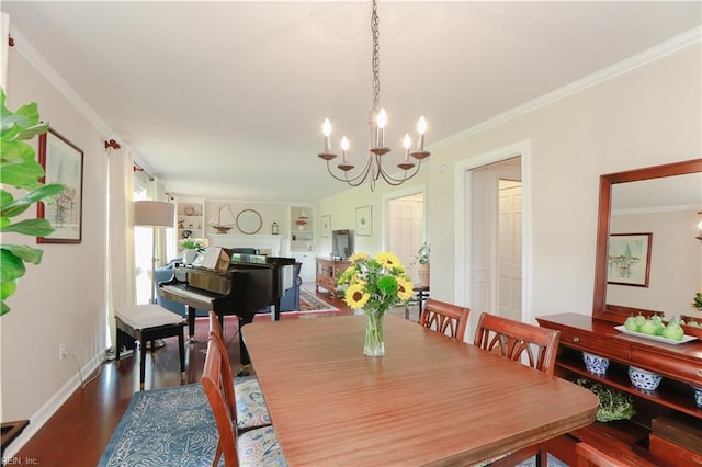 dining room with dark wood finished floors, built in features, an inviting chandelier, crown molding, and a fireplace