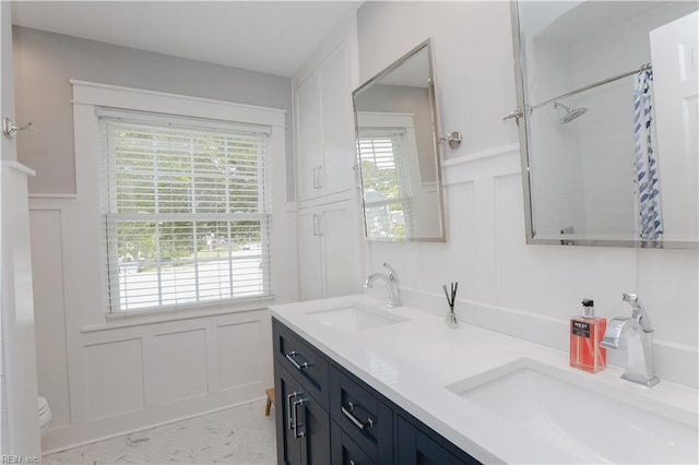 bathroom with plenty of natural light, a decorative wall, and a sink