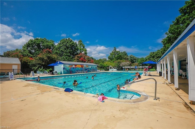 community pool featuring fence and a patio area