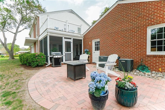 view of patio / terrace featuring a sunroom, central AC, area for grilling, and a balcony