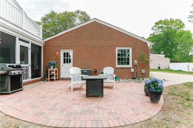 view of patio with cooling unit, a sunroom, and area for grilling