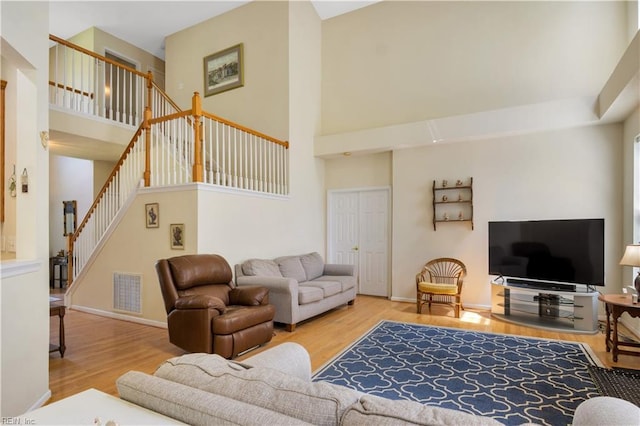 3733 Captain Wynne Dr, Williamsburg, VA 23185 - living area featuring visible vents, wood finished floors, stairway, baseboards, and a high ceiling