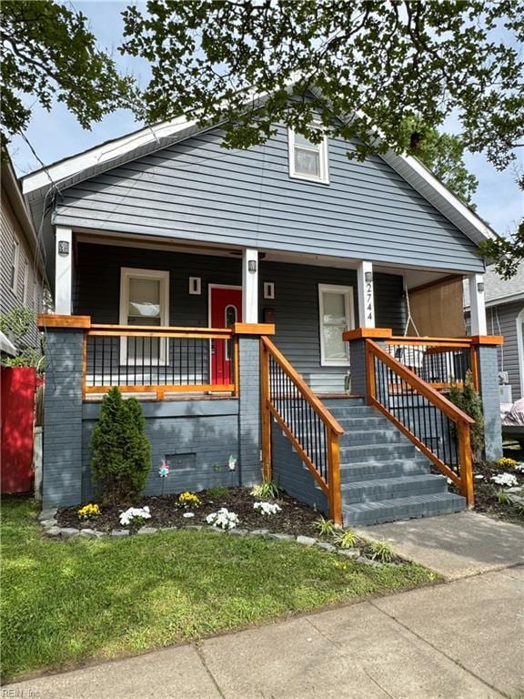 bungalow-style house with covered porch and a front yard