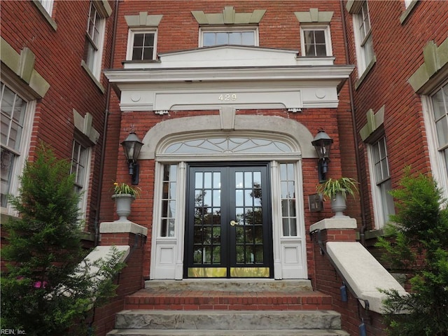 doorway to property featuring brick siding and french doors